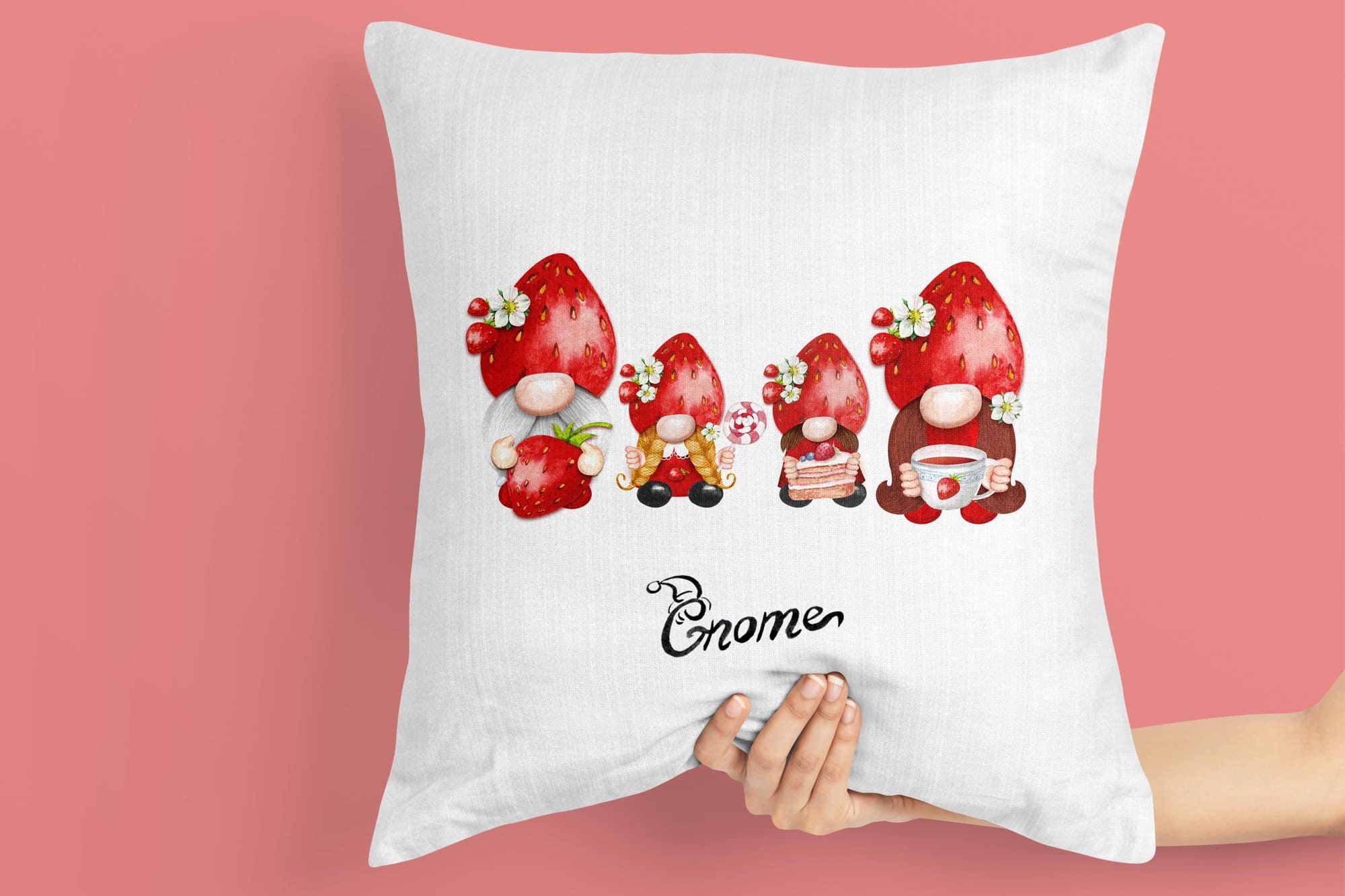 A white pillow with a picture of a family of gnomes in strawberry hats.