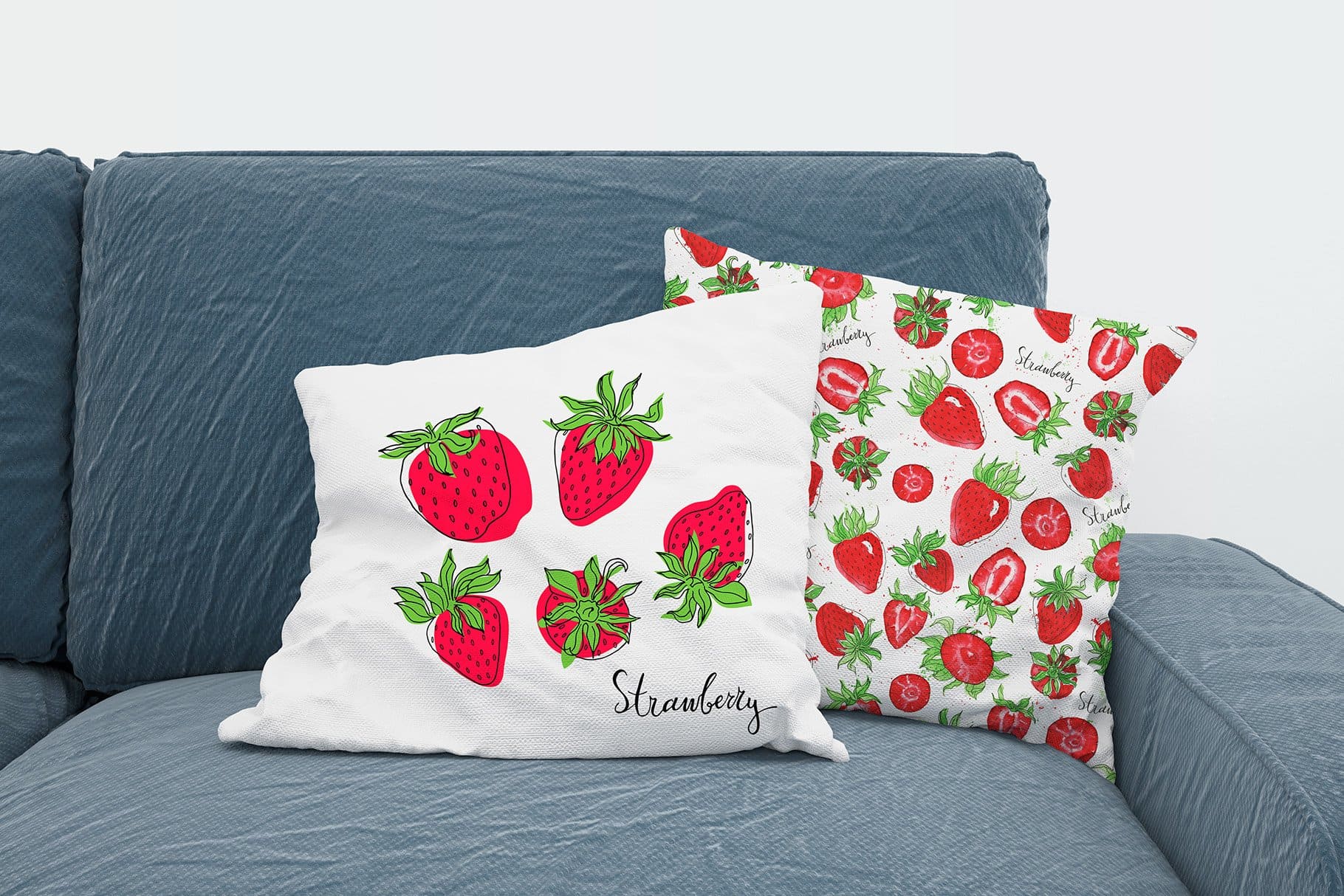 Two pillows, one with a large strawberry print and the other with a small drawn strawberry.