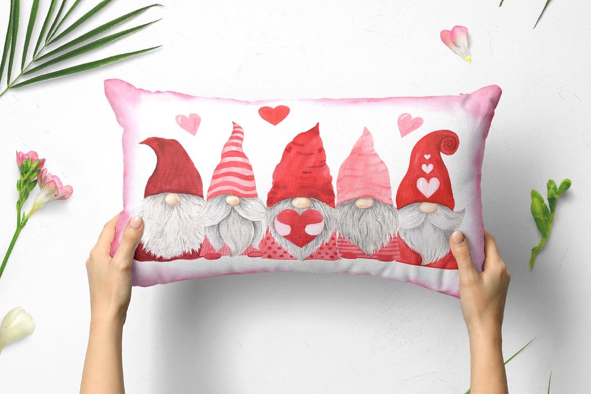 Five Valentine gnomes are depicted on a white pillow.