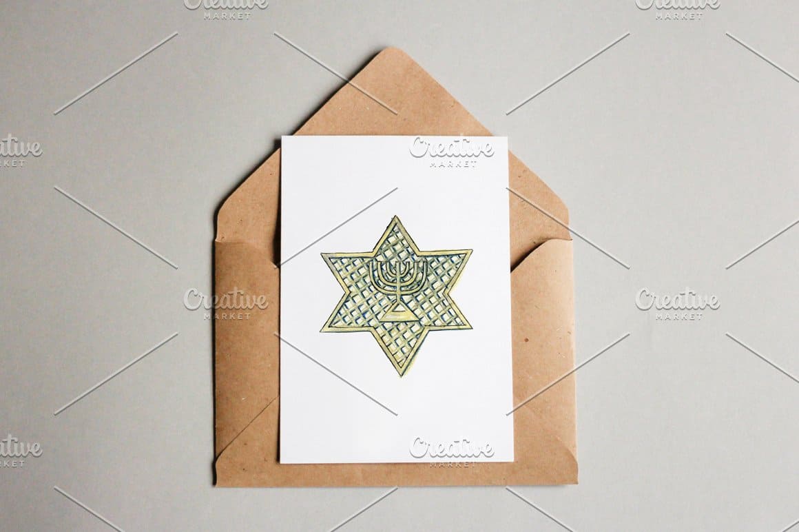 On the beige envelope lies a white card with a painted David star.