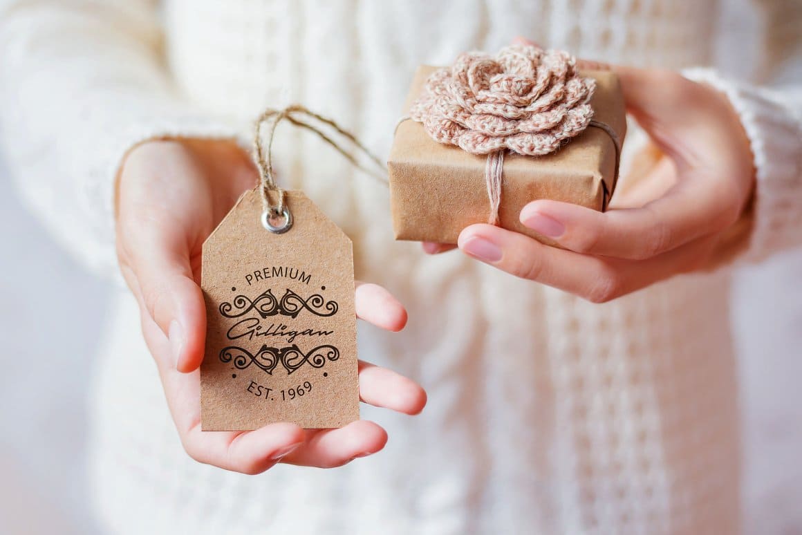 A cardboard tag with a special handwritten font and a small gift made of similar material.