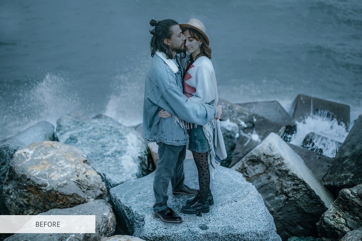 A couple in love is standing on a stone near the sea.