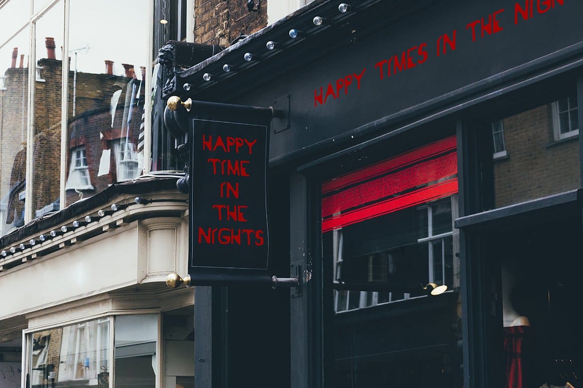 A sign on a store with the inscription "Happy time in the nights" on a black background.