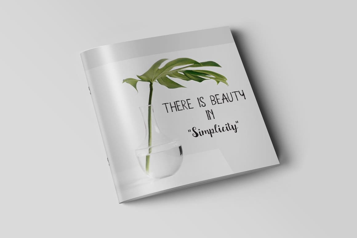 A white book with a green tropical leaf in a vase and the inscription "There is beauty in "Simplicity"".