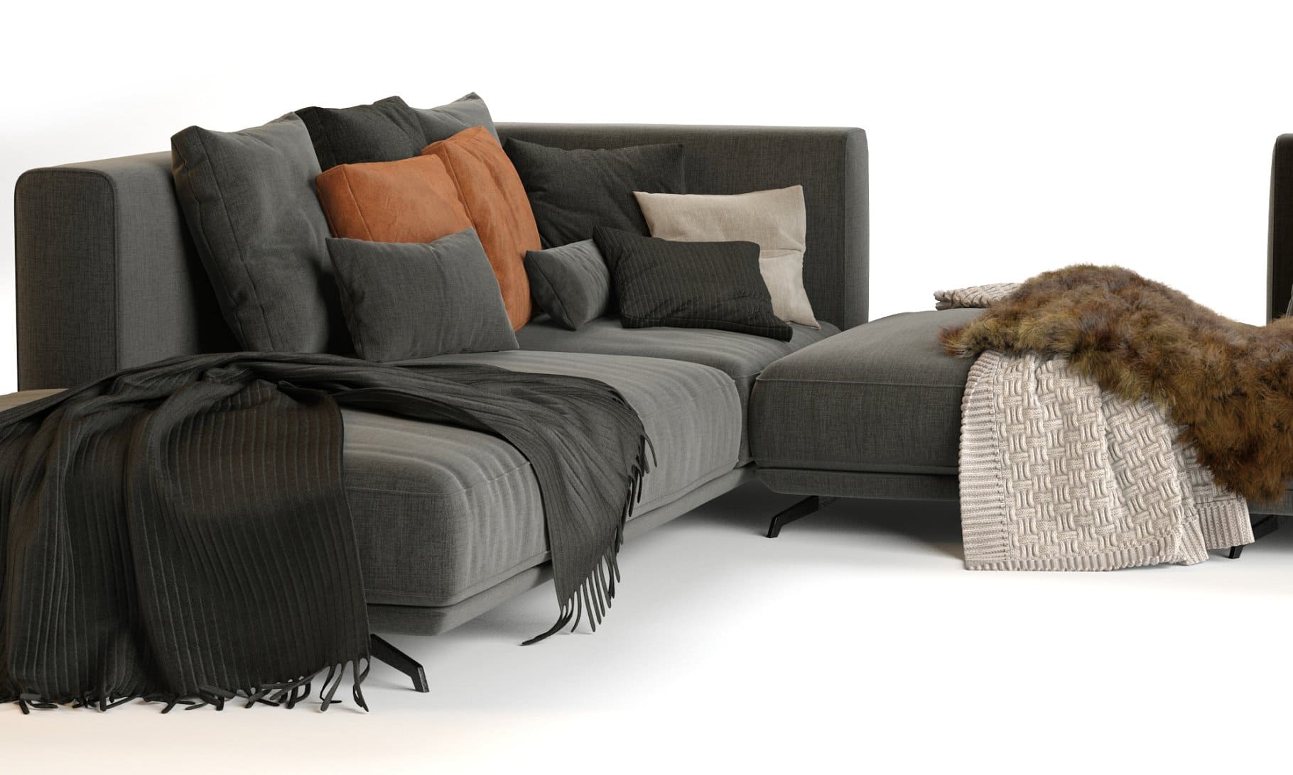 Knitted blankets and blankets made of fur and fabric lie on the Dalton Sofa by Ditre Italia.