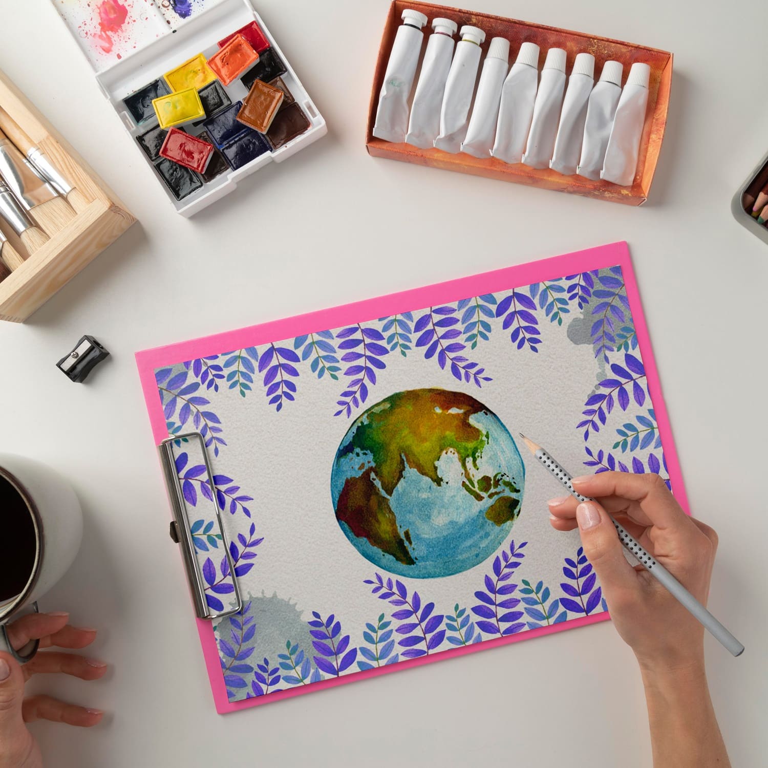 A watercolor planet Earth is drawn on a white sheet of paper.
