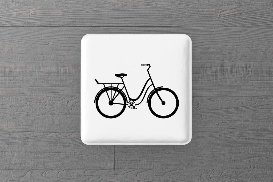 Silhouette of a bicycle on a white magnet lying on a wooden floor.